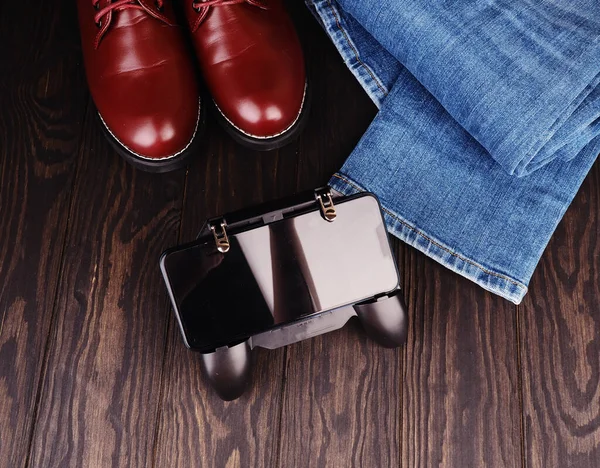Мужской досуг концепция, джинсы, кожаная обувь, джойстик на телефоне место для дизайна — стоковое фото