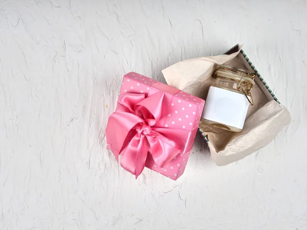 Jeden słoik śmietany, pusta etykieta balsamu w pudełku z różową wstążką — Zdjęcie stockowe