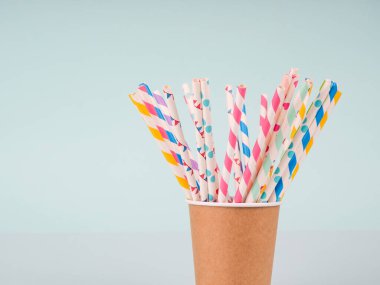 Bardakta birkaç renkli kokteyl tüpü var..