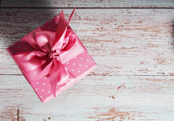 Een Geschenkdoos Met Een Roze Strikje Een Houten Achtergrond Kopie — Stockfoto