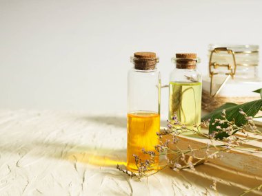 İki şişe yağ, cilt bakımı, aromaterapi, ahşap bir standın üzerinde durmak, kurumuş çiçekler..