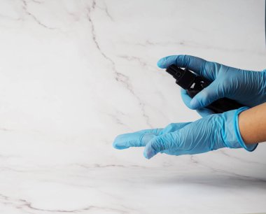 Tıbbi eldivenlerdeki eller salgını önlemek için antiseptik tutuyor. el dezenfektanı alkol uyguluyor..