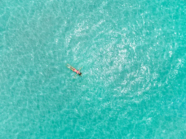 A mulher na superfície da água azul-turquesa — Fotografia de Stock