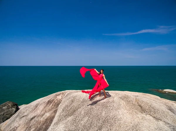 Femme sur le rocher en robe de vol rouge — Photo