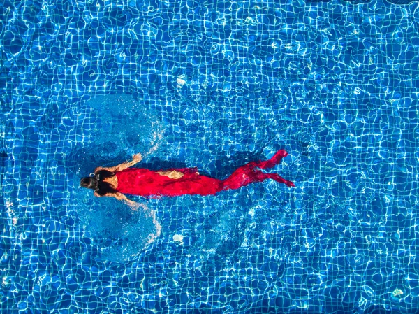 Woman in swimming pool in red dress — Stock Photo, Image