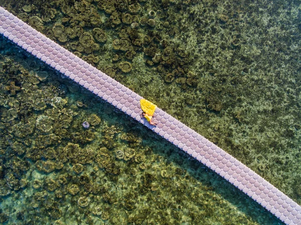 Žena v létání žluté šaty na pontonový most — Stock fotografie