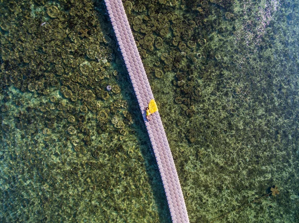 Mujer en vestido amarillo volador en puente de pontón — Foto de Stock