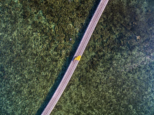Woman in flying yellow dress on pontoon bridge — Stock Photo, Image