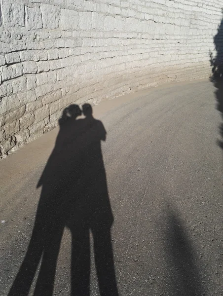 Dois juntos povos sombra na parede de tijolo Fotos De Bancos De Imagens Sem Royalties