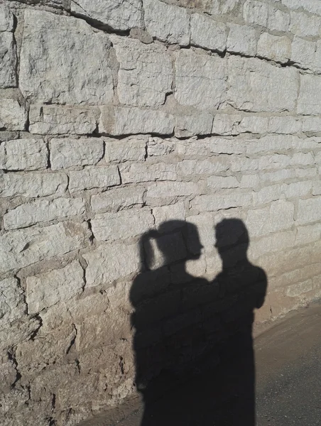Dois juntos povos sombra na parede de tijolo Imagens De Bancos De Imagens Sem Royalties