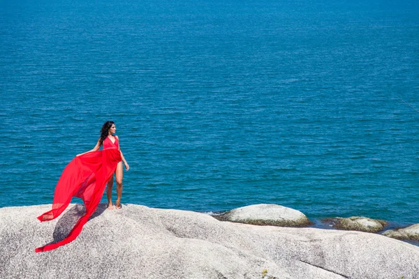 Femme en robe jaune volant sur un rocher — Photo