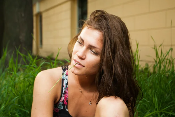 Model duduk di rumput hijau pada waktu musim panas — Stok Foto