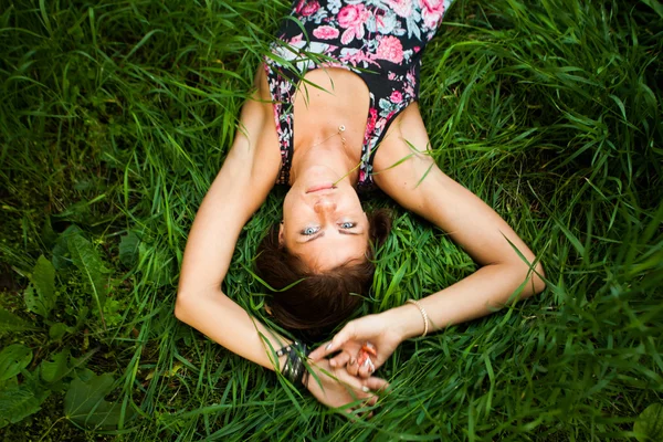 Model berbaring di rumput hijau pada waktu musim panas — Stok Foto