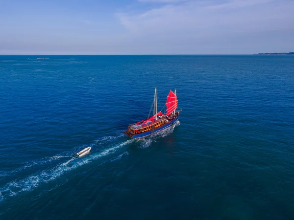 Kırmızı yelkenli gemi deniz kenarında geliyor havadan görünümü — Stok fotoğraf