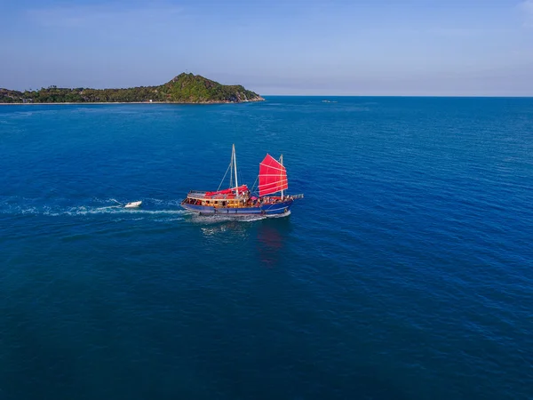 Kırmızı yelkenli gemi deniz kenarında geliyor havadan görünümü — Stok fotoğraf
