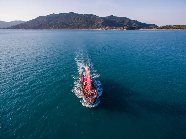 Kırmızı yelkenli gemi deniz kenarında geliyor havadan görünümü — Stok fotoğraf