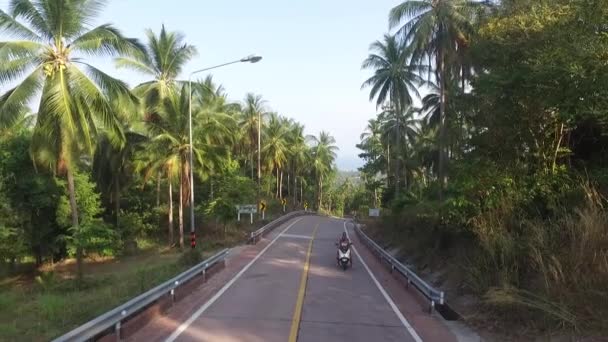 Letecký pohled na motocyklista jízda na silnici v džungli — Stock video