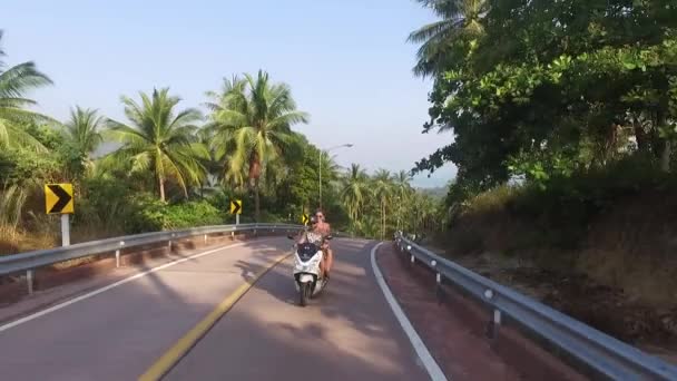 Veduta aerea di un motociclista che guida su una strada nella giungla — Video Stock