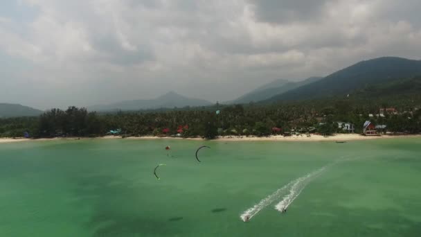 Vista aérea del kitesurf en las aguas poco profundas de la isla — Vídeos de Stock