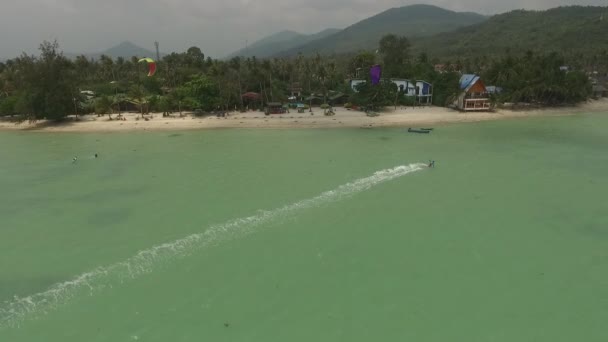 Vista aérea del kitesurf en las aguas poco profundas de la isla — Vídeos de Stock