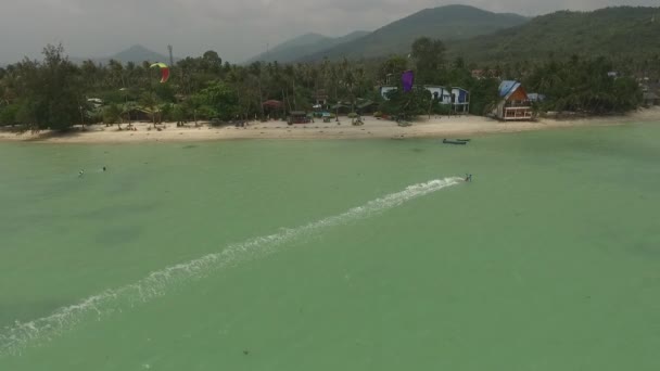 Vista aérea del kitesurf en las aguas poco profundas de la isla — Vídeo de stock