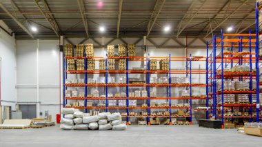 Rafların yanında palet kamyonu olan modern bir mağaza deposu.