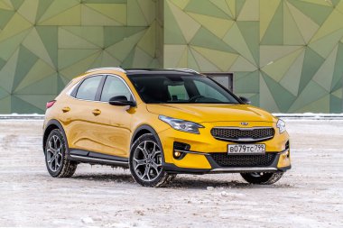 MOSCOW, Rusya - 10 HAZİRAN 2021 KIA XCeed. AWD Hatchback arazi aracı. 2020 yılında yeni KIA XCeed geçiş modeli. Kışın arka planda sarı KIA. Kia Motors tarafından üretilen kompakt SUV araba. Ön taraf yakın görünüm