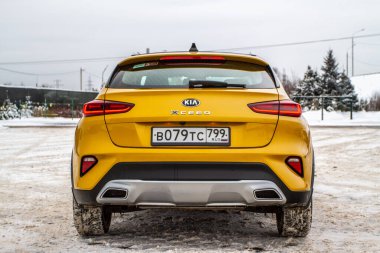 MOSCOW, Rusya - 10 HAZİRAN 2021 KIA XCeed. AWD Hatchback arazi aracı. 2020 yılında yeni KIA XCeed geçiş modeli. Kışın arka planda sarı KIA. Kia Motors tarafından üretilen kompakt SUV araba. Ön taraf yakın görünüm