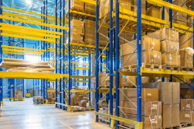 Üst raflarda sıra sıra eşya kutuları olan modern bir deponun içinde.