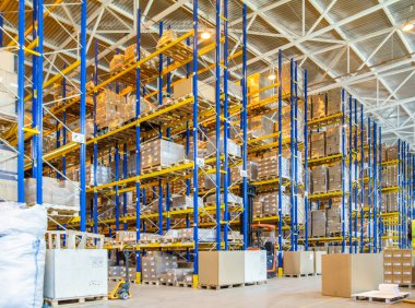 Üst raflarda sıra sıra eşya kutuları olan modern bir deponun içinde.