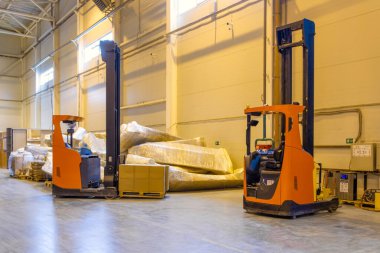 Forklift lojistik deposuna park ediyor. Modern bir deponun içinde palet istifleyici kamyon ekipmanı