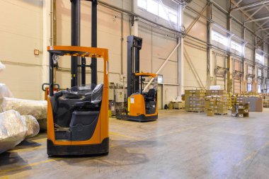 Forklift lojistik deposuna park ediyor. Modern bir deponun içinde palet istifleyici kamyon ekipmanı
