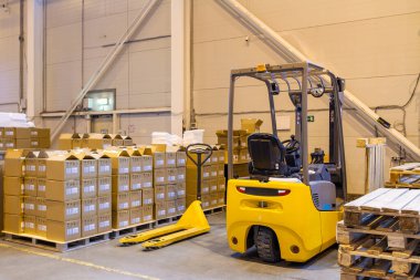 Forklift lojistik deposuna park ediyor. Modern bir deponun içinde palet istifleyici kamyon ekipmanı
