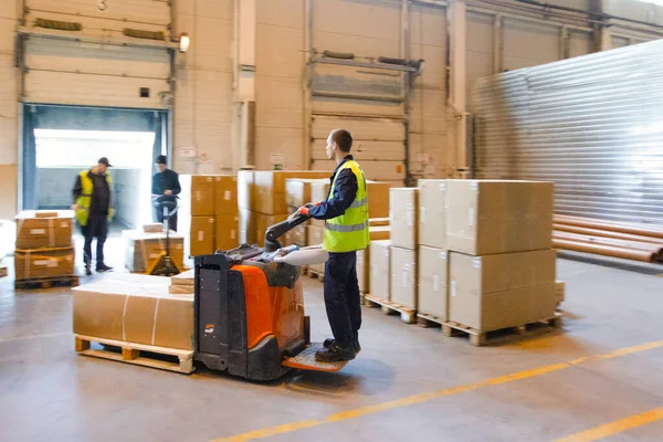 MOSCOW, RUSSIA - 18 Mart 2021 Depo işçisi depoda içi mal dolu bir forklift kullanıyor.
