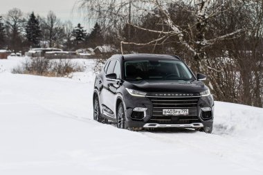 MOSKOW, Rusya - 23 Şubat 2021 TXL SUV SUV 'u yakın görüş açısına alın. Siyah AWD SUV, Çin firması tarafından üretilen kış arkaplanı. Chery Exeed TXL kompakt SUV arabası. Doğada kesişme.