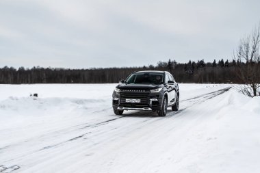 MOSKOW, RUSYA - 23 Şubat 2021 TXL SUV SUV Öne doğru hareket ediyor. Çin firması tarafından üretilen siyah arazi aracı. Chery Exeed TXL Küçük çaplı araba hareket halinde.