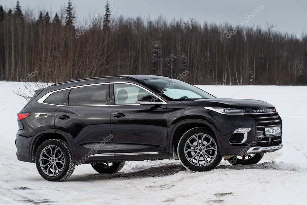 MOSCOW, RUSSIA - FEBRUARY 23, 2021 CHERYEXEED TXL SUV car front side close up view. Black AWD SUV on winter background produced by Chinese company. Chery Exeed TXL Compact SUV car. Crossover at nature.