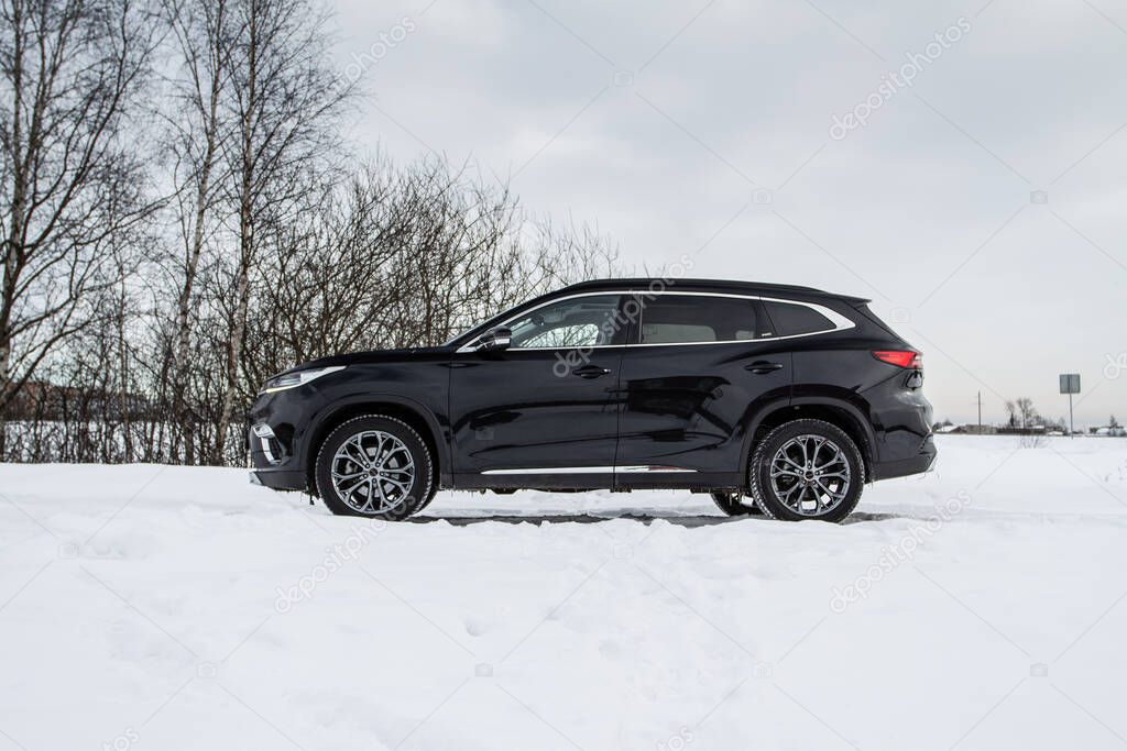 MOSCOW, RUSSIA - FEBRUARY 23, 2021 CHERYEXEED TXL SUV car front side close up view. Black AWD SUV on winter background produced by Chinese company. Chery Exeed TXL Compact SUV car. Crossover at nature.