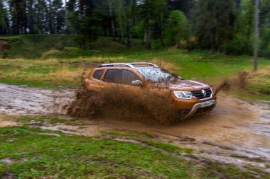 MOSCOW, RUSSIA - Mayıs 08, 2021 Renault Duster ikinci nesil dış görünüş hareket halinde. Ayrıca Dacia Duster adında kompakt bir SUV aracı yağmur altında arazide araba sürüyor. Off-road engeli