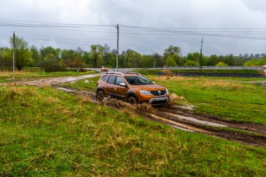 MOSCOW, RUSSIA - Mayıs 08, 2021 Renault Duster ikinci nesil dış görünüş hareket halinde. Ayrıca Dacia Duster adında kompakt bir SUV aracı yağmur altında arazide araba sürüyor. Off-road engeli