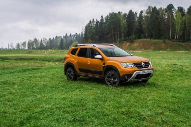MOSCOW, Rusya - Mayıs 08, 2021 Renault Duster ikinci nesil. Dacia Duster olarak da bilinen kompakt SUV arabası. Dış cephe sahadaki doğa off-road arka planına yakından bakıyor. Turuncu 4x4 araba.