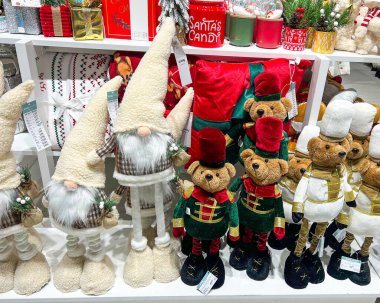 6 Kasım 2025 'te Polonya' nın Varşova kentindeki bir alışveriş merkezinin perakende rafında Noel temalı dekorasyonlar sergilendi. Sergide konforlu cüceler, şenlikli kıyafetler içindeki oyuncak ayılar, tatil mumları, yastıklar ve mevsimlik hediyeler yer alıyor..