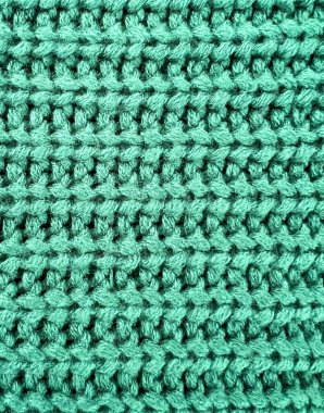 Ayrıntılı iplik desenli yeşil örülmüş kumaş dokusu. Moda tasarımı, el yapımı projeler, kış temaları ve yaratıcı tasarımlar için rahat tekstil arka planı.
