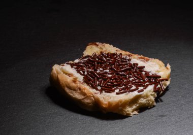 Halved raisin bun with chocolate sprinkles (hagelslag) in studio light, ideal for breakfast and food culture themes
