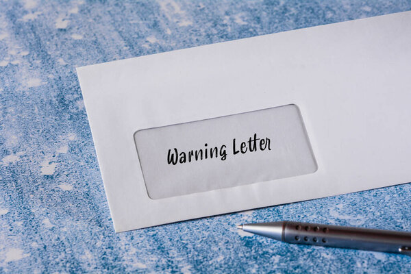 Close up of a formal warning notice letter envelope symbolizing legal action, employment issues, compliance procedures and administrative processes