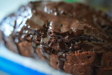 Ev yapımı çikolatalı kekin parlak, zengin bir cilalı, pürüzsüz bir dokusu, iştah açıcı detayları ve ev yapımı sıcak, davetkar bir tatlı atmosferi var..