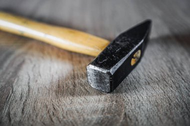 Yıpranmış metal çekiç ve ahşap sapı, kopya alanı olan ahşap bir arka planda izole edilmiş.