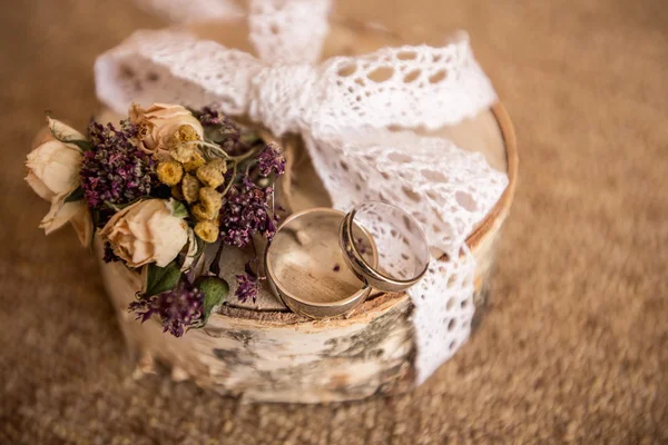 Anéis de casamento com flor em madeira — Fotografia de Stock