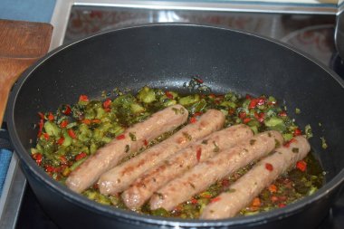 Baharatlı ve sebzeli kızarmış domuz sosisi.