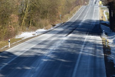 Kışın yol karla kaplı ağaçlar ve mavi gökyüzü